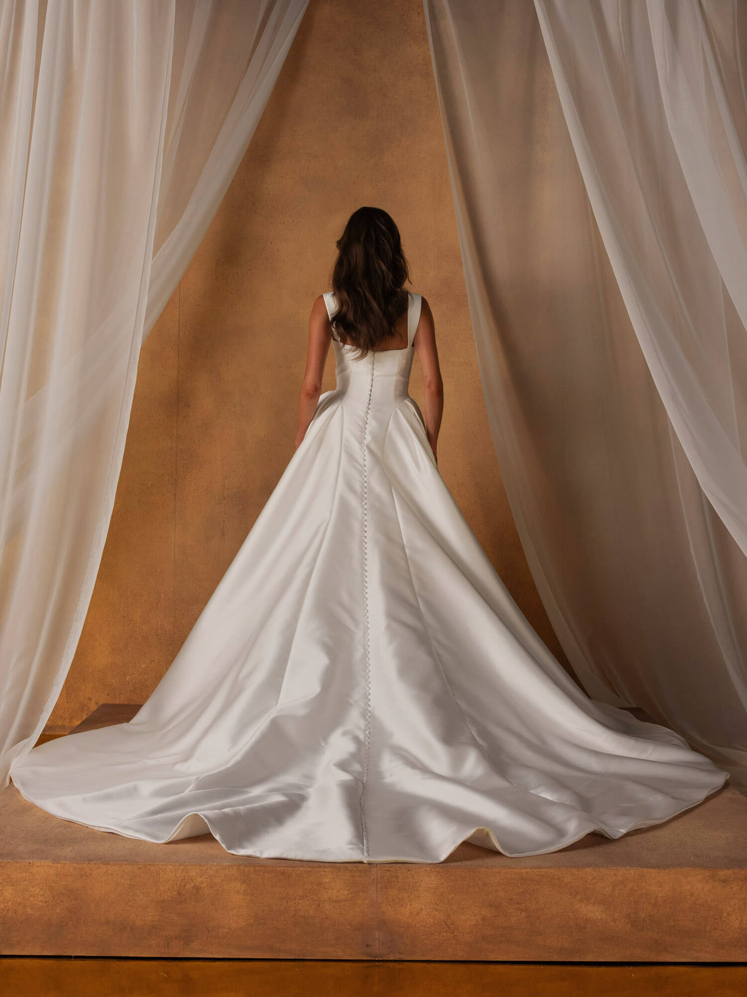 schlichtes Prinzessin-Brautkleid mit langer Schleppe und durchgehender Knopfleiste am Rücken, Bridal-Fashion Highlight für Hamburg.