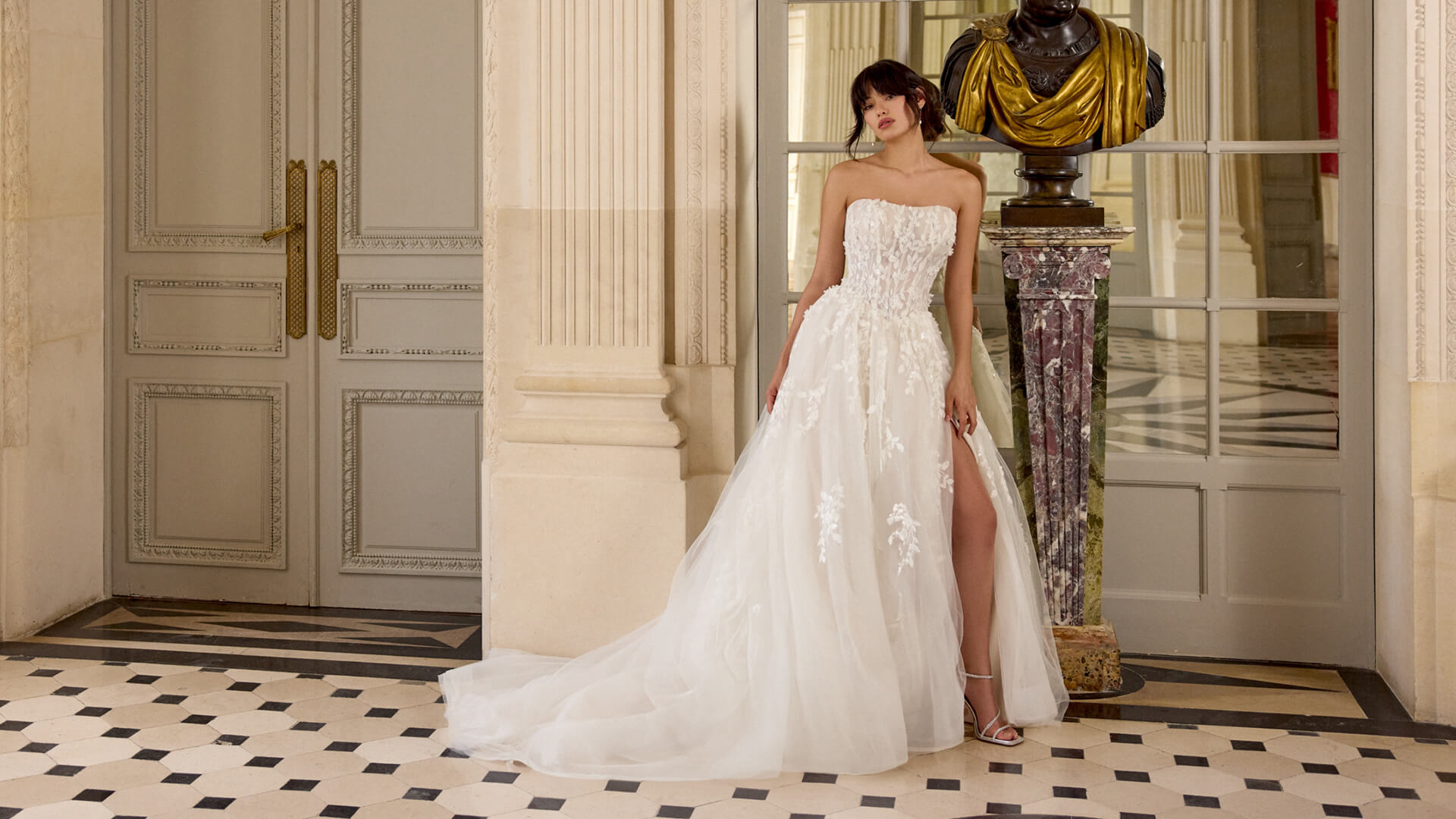 Märchenhaftes Brautkleid im A-Linien-Stil mit trägerloser Spitzen-Corsage, hohem Beinschlitz und fließendem Tüllrock, exklusiv erhältlich in Cuxhaven.