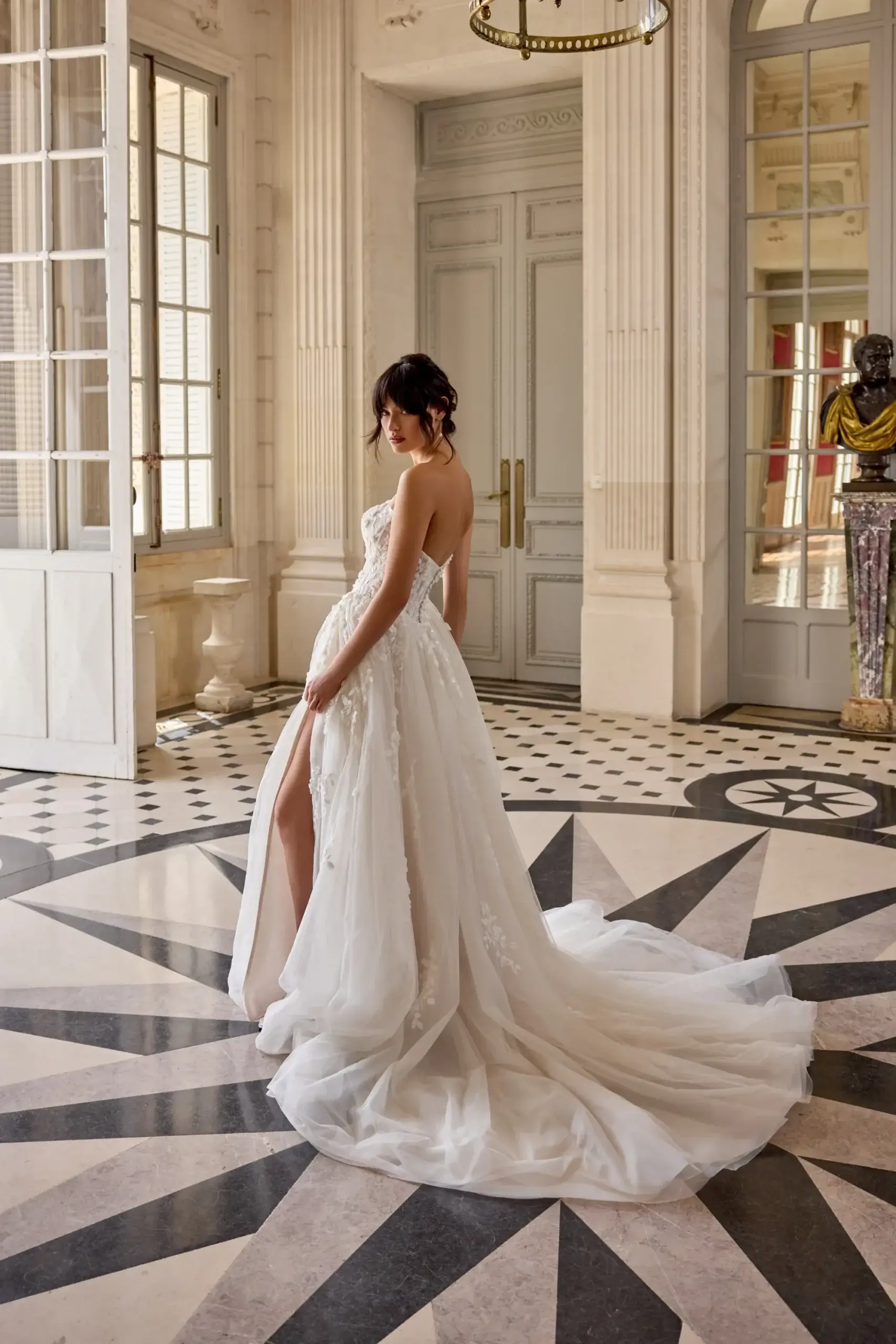 Märchenhaftes Brautkleid im A-Linien-Stil mit trägerloser Spitzen-Corsage, hohem Beinschlitz und fließendem Tüllrock, exklusiv erhältlich in Cuxhaven.