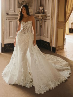 Kleidergalerie Trägerloses Meerjungfrau-Brautkleid mit halbtransparenter Korsage, floraler Glitzerspitze und einem abnehmbaren, voluminösen Überrock mit Schleppe
