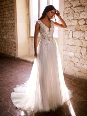 omantisches Vintage-Brautkleid mit V-Ausschnitt, kleinen Cap-Sleeve-Ärmeln, transparenter Korsage mit Perlen und fließendem Tüllrock. Hochwertige Brautmode in Cuxhaven nahe Bremen und Oldenburg.