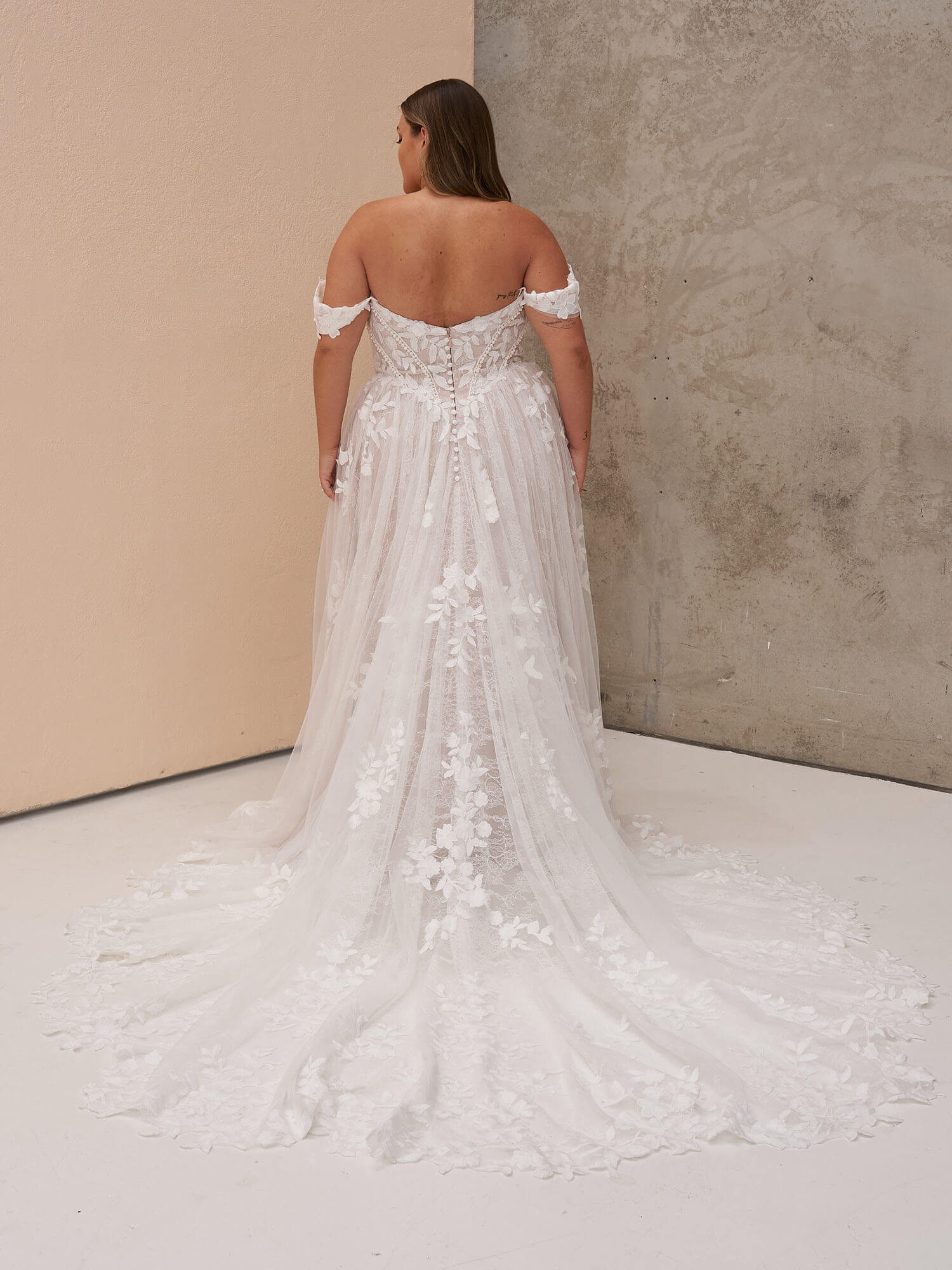 Romantisches A-Linien-Brautkleid in Ivory mit drapierten Carmen-Trägern, herzförmigem Ausschnitt und floralen Spitzenapplikationen auf dem Tüllrock. Brautmode in Cuxhaven.
