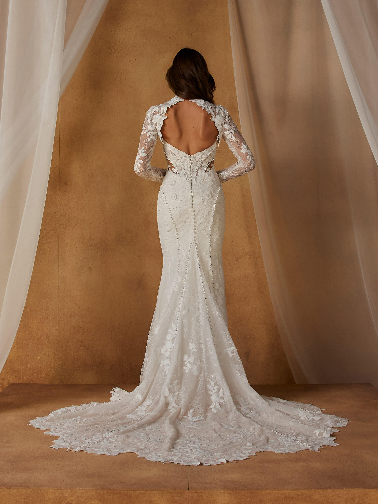 Exklusives Meerjungfrau-Brautkleid mit floraler Spitze, Perlenstickerei und einem hochgeschlossenen Langarm-Oberteil mit Stehkragen und Keyhole-Ausschnitt. Verfügbar im Brautmodenstudio Cuxhaven.