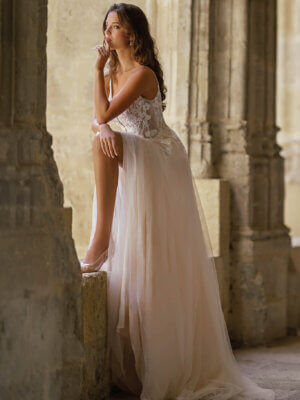 Fließendes A-Linien-Brautkleid im romantischen Stil mit floralem Spitzenmieder, zarten Perlen-Spaghettiträgern und hohem Beinschlitz im Tüllrock, fotografiert für das Brautmodenstudio Cuxhaven.