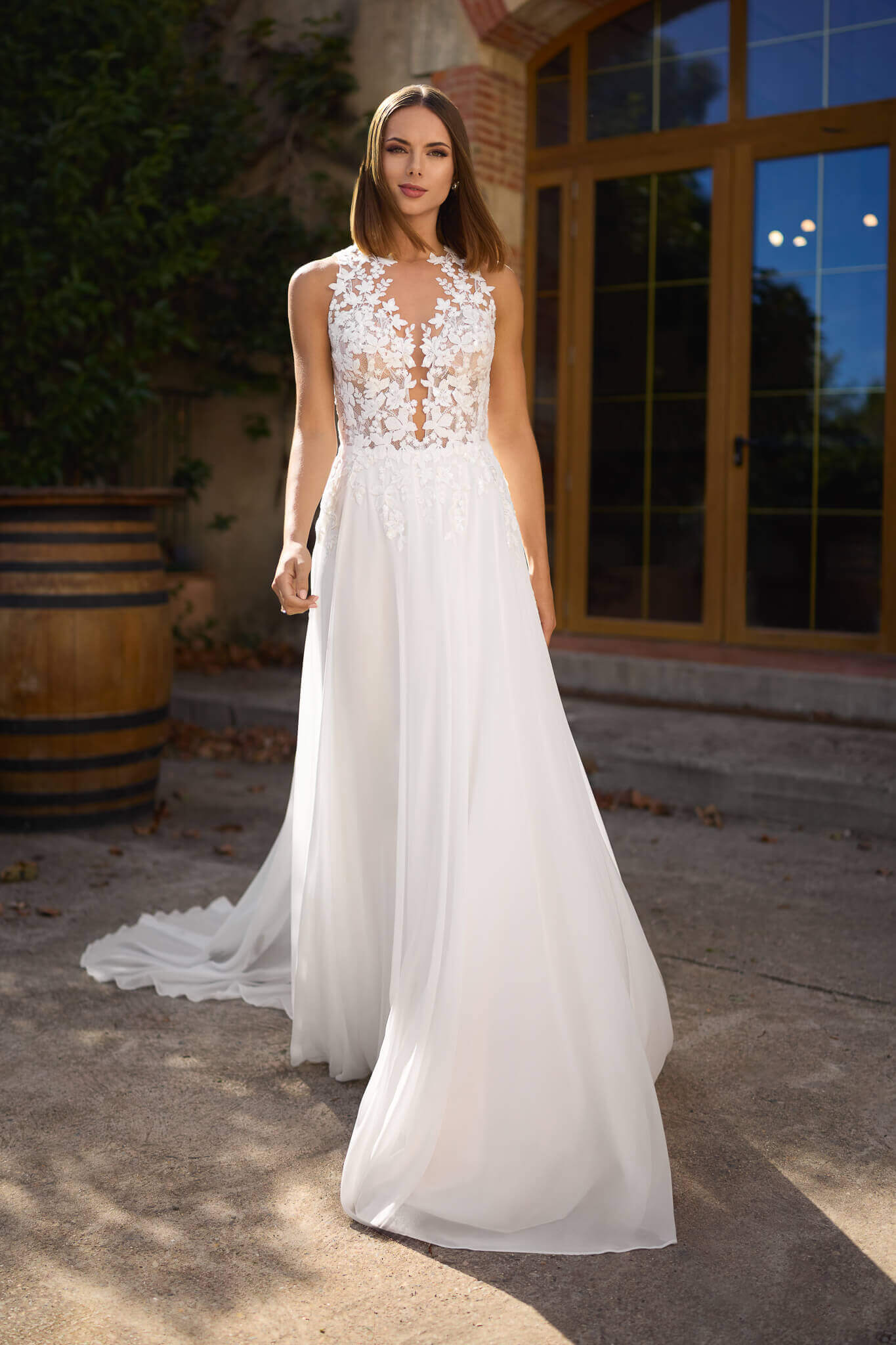 Leichtes Brautkleid im romantischen A-Linien-Stil mit tiefem Plunging-Ausschnitt, floraler Illusionsspitze am hochgeschlossenen Mieder und fließendem Chiffonrock, exklusiv präsentiert in Cuxhaven.