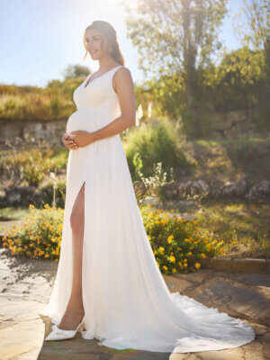 Fließendes Umstandsbrautkleid im Clean-Chic-Stil aus softem Chiffon mit V-Ausschnitt, hohem Beinschlitz und feiner Schleppe, exklusiv präsentiert im Brautmodengeschäft Cuxhaven für Schwangere aus dem Raum Bremen und Stade.