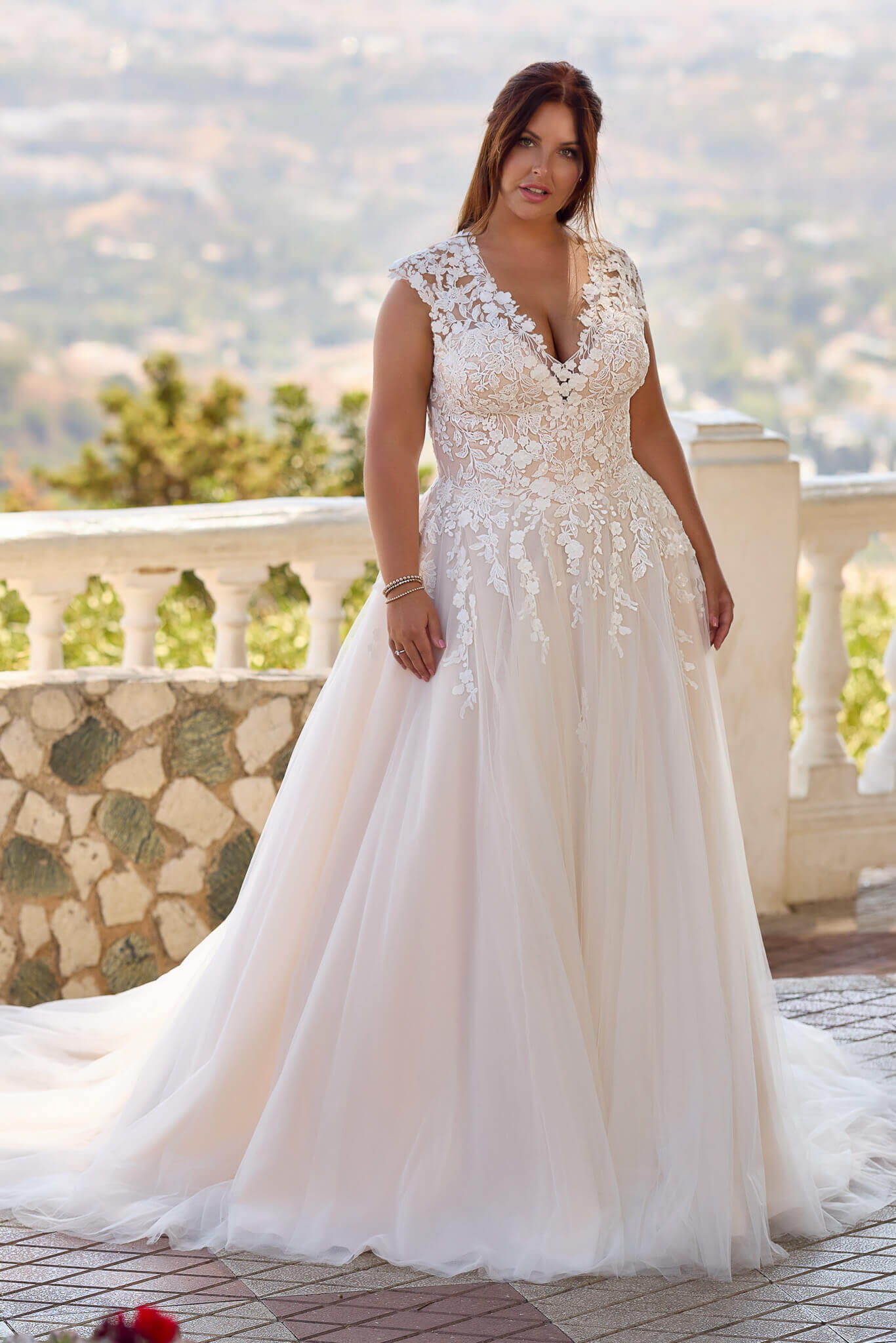 Romantisches Curvy-Brautkleid im A-Linien-Stil mit tiefem V-Ausschnitt, floralen Spitzenapplikationen und weich fallendem Softtüll, exklusiv erhältlich in Cuxhaven.