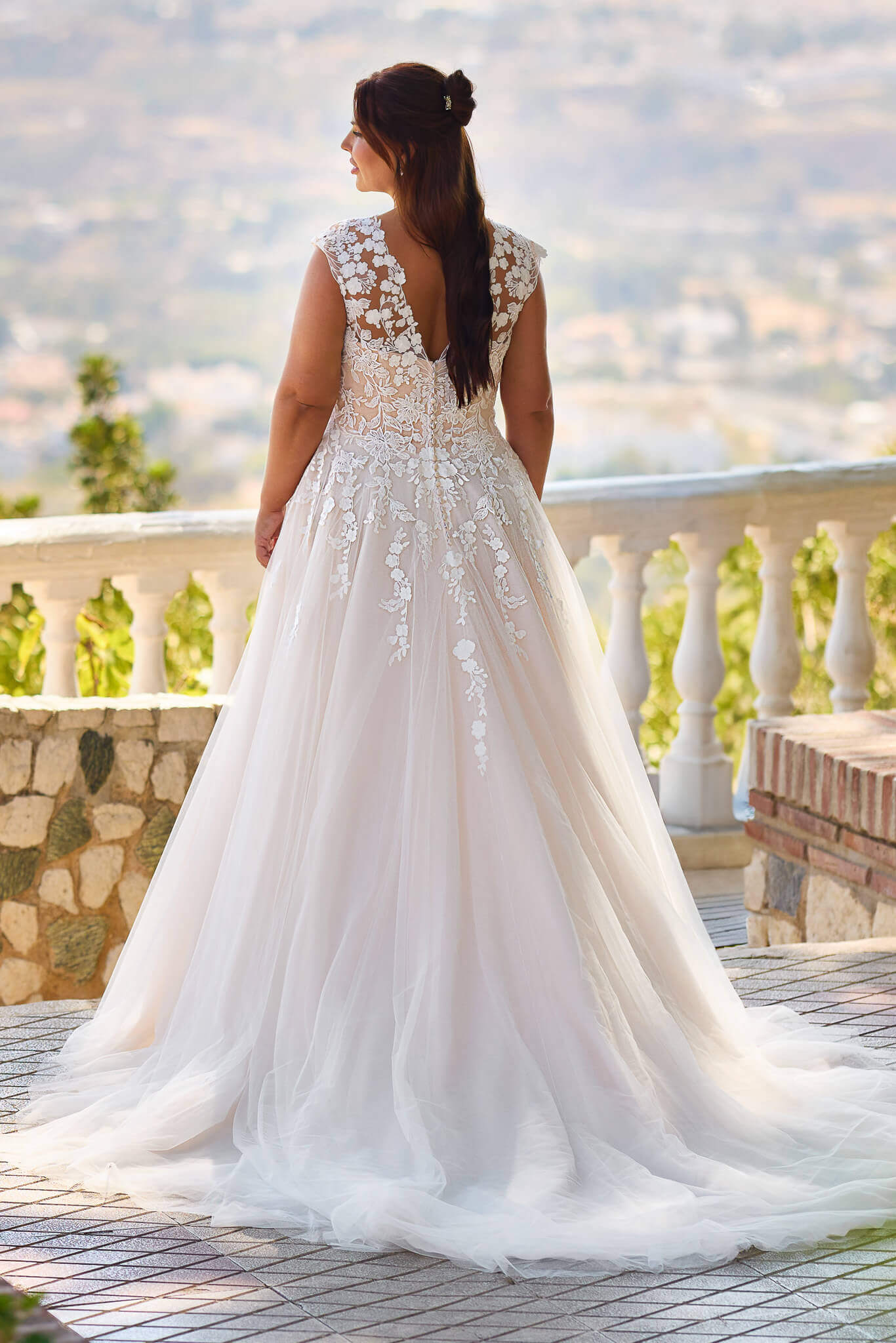 Romantisches Curvy-Brautkleid im A-Linien-Stil mit tiefem V-Ausschnitt, floralen Spitzenapplikationen und weich fallendem Softtüll, exklusiv erhältlich in Cuxhaven.
