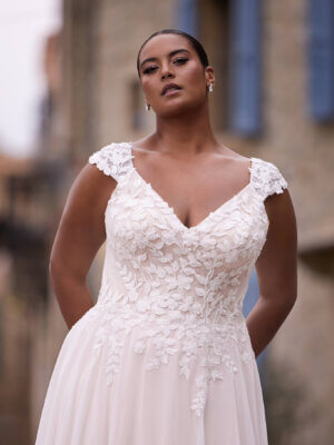 Romantisches Curvy-Brautkleid im A-Linien-Stil mit zarten Cap-Sleeves, floraler Spitzenstickerei und fließendem Chiffonrock, exklusiv erhältlich in Cuxhaven.